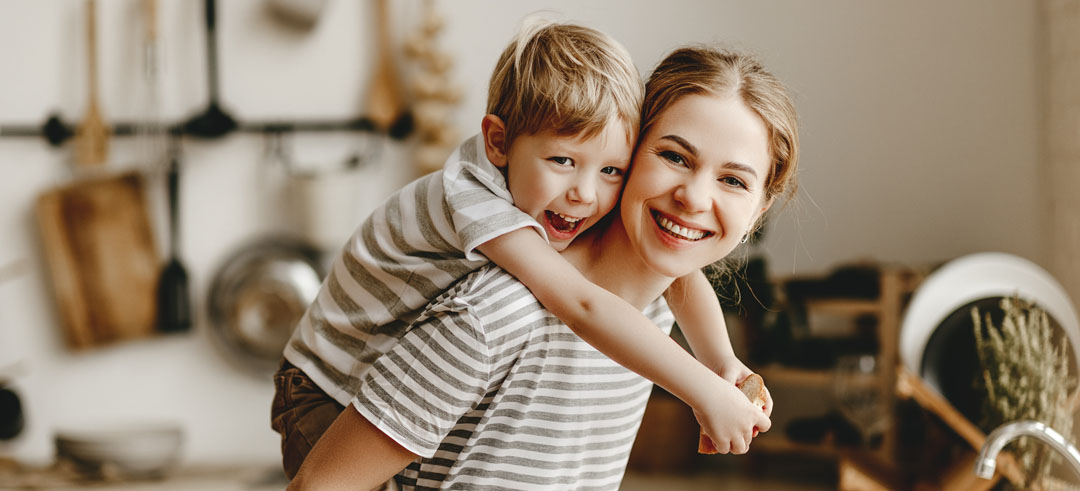 Madre llevando a su hijo sobre su espalda