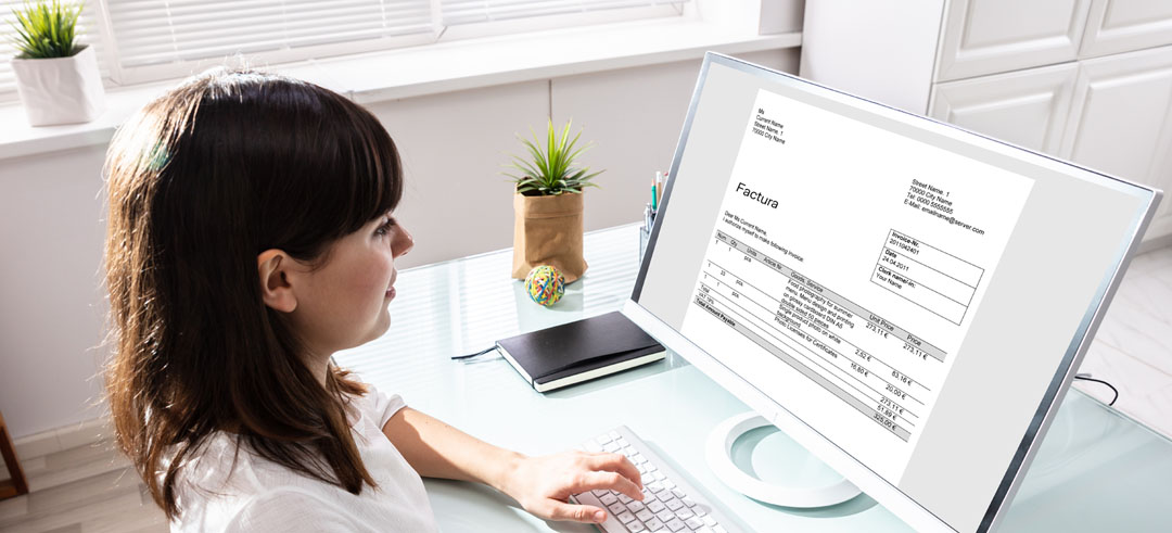 Mujer consultando una factura desde el ordenador