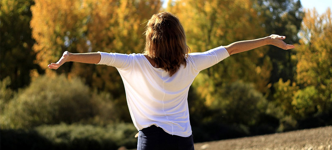 Mujer estirándose en un bosque