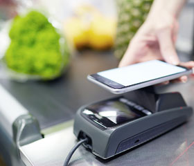 Persona pagando con el móvil sobre un datafono