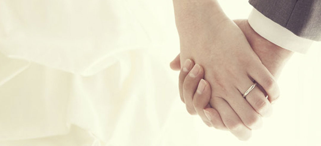 Dos manos agarradas mientras se casan